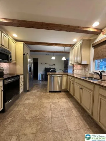 a large kitchen with stainless steel appliances and cabinets