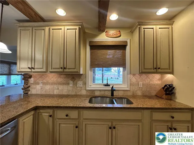 a kitchen with stainless steel appliances granite countertop a sink a refrigerator and a granite counter tops