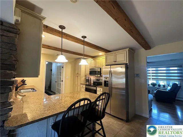 a kitchen with refrigerator and chairs