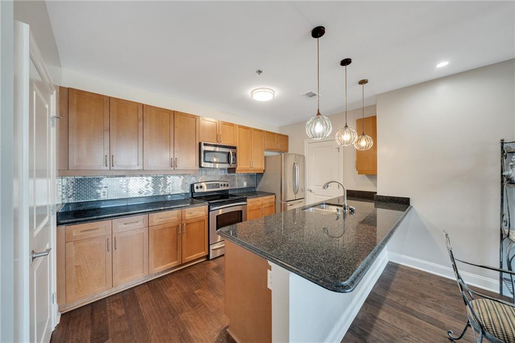 325 East Paces Ferry Road Northeast, Unit 601 Atlanta, GA 30305 - Photo 3 of 28 a kitchen with stainless steel appliances granite countertop a sink dishwasher and refrigerator with wooden floor