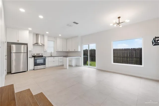 a view of kitchen with stainless steel appliances refrigerator oven and cabinets
