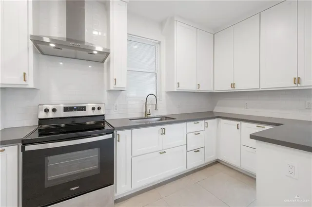 a kitchen with granite countertop white cabinets and stainless steel appliances