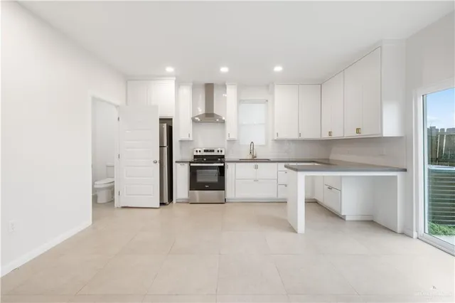 a large kitchen with cabinets white stainless steel appliances