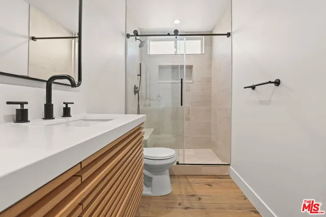 a bathroom with a sink a toilet and shower