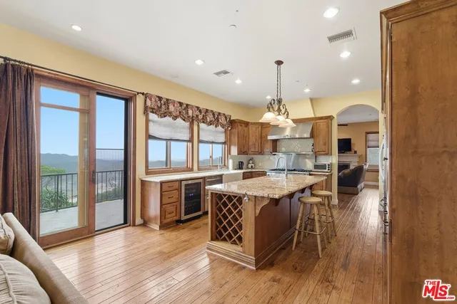 a kitchen with kitchen island granite countertop a stove and a wooden floors
