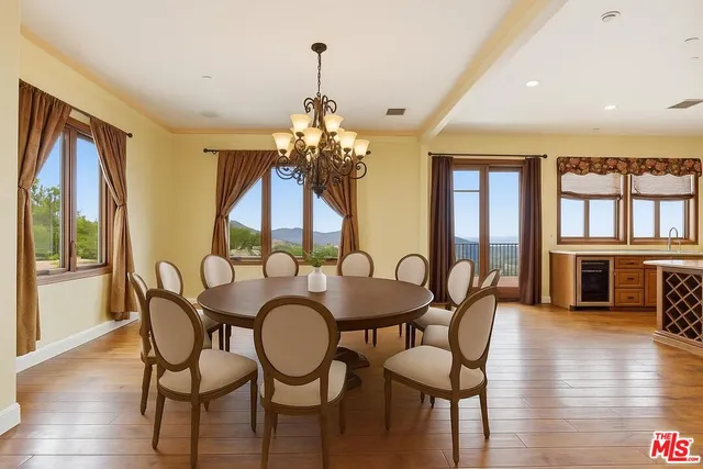 a dining room with furniture a chandelier and wooden floor