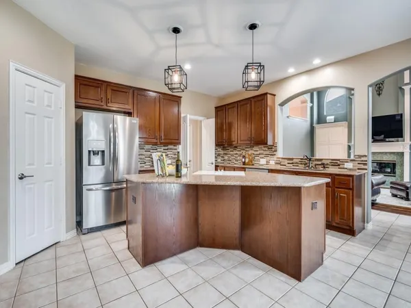 a kitchen with stainless steel appliances granite countertop a refrigerator a stove a sink dishwasher and a refrigerator with wooden floor