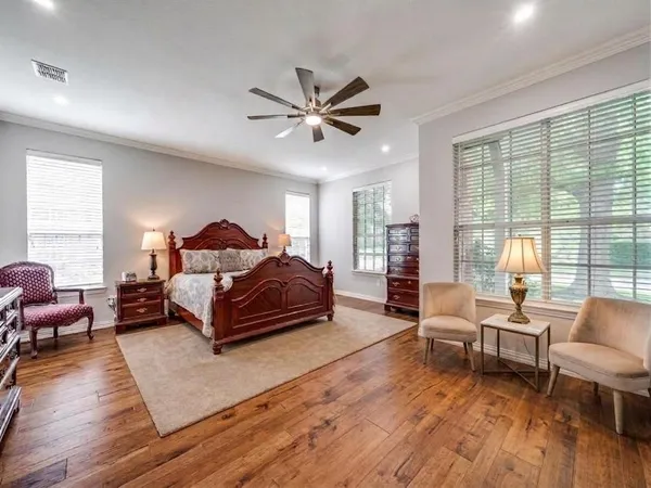 a spacious bedroom with a bed a couch and a window
