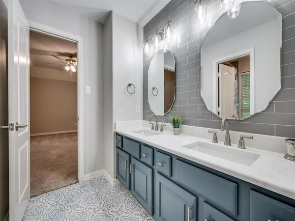 a bathroom with double vanity sinks and a mirror
