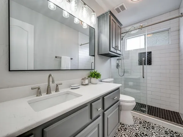 a bathroom with a sink toilet a mirror and shower