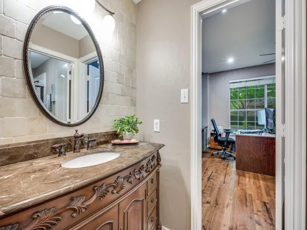 a en suite bathroom with a granite countertop sink and a mirror