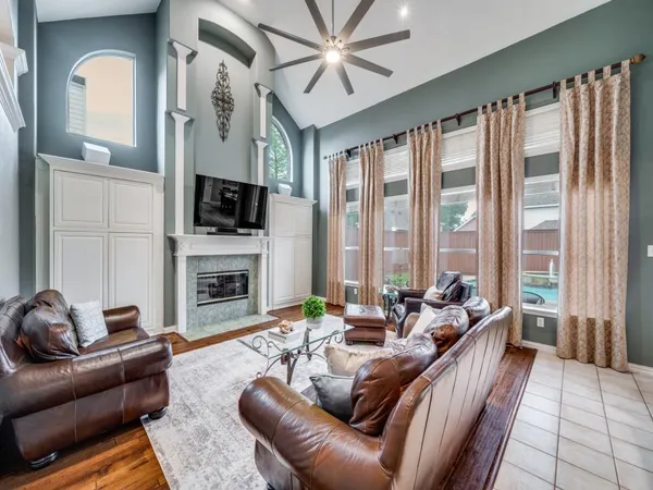 a living room with furniture fireplace and a large window