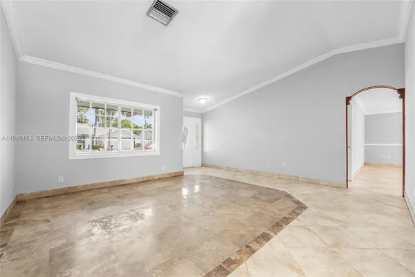 an empty room with windows and ceiling fan