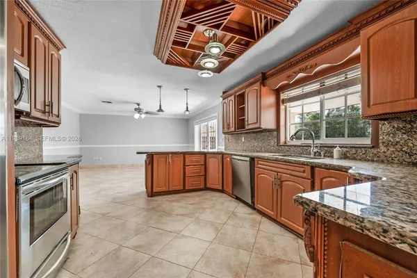 a kitchen with stainless steel appliances granite countertop a sink stove and cabinets