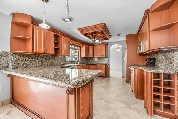 a kitchen with stainless steel appliances granite countertop a sink and a refrigerator