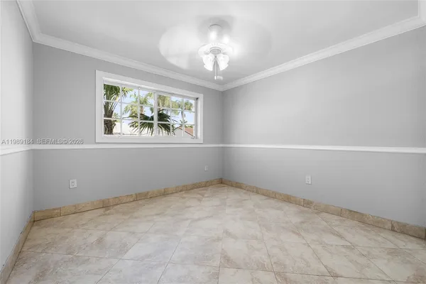 an empty room with windows and chandelier fan