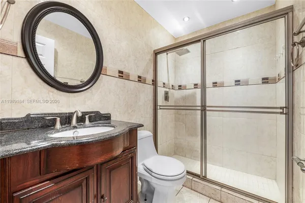 a bathroom with a granite countertop sink toilet and a mirror