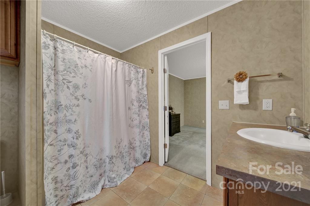 1217 Reservation Road Rock Hill, SC 29730 - Photo 14 of 32 a bathroom with a granite countertop sink a mirror and shower