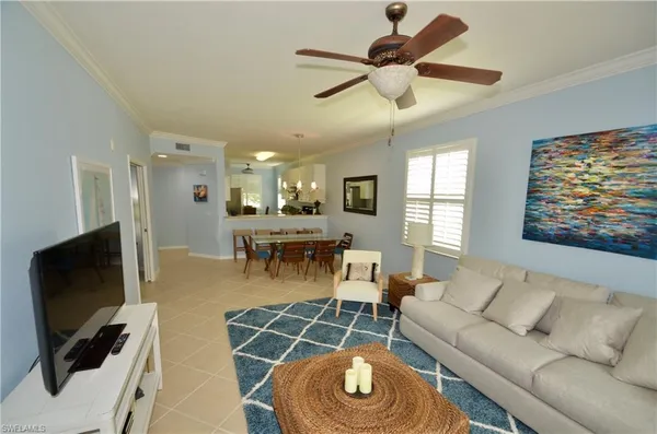 a living room with furniture a flat screen tv and a window