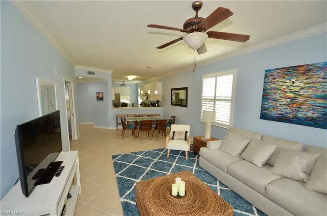 a living room with furniture a flat screen tv and a window