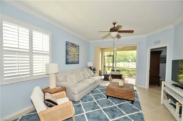 a living room with furniture a large window and a chandelier