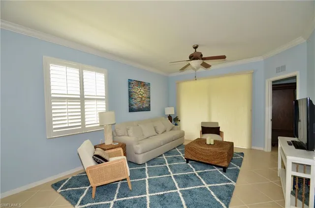 a living room with furniture a flat screen tv and a window