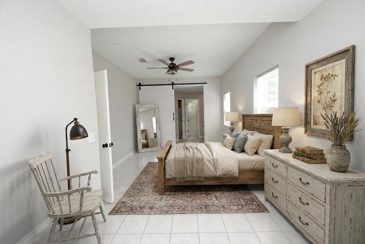 22831 John Rolfe Lane Katy, TX 77449 - Photo 19 of 34 a spacious bedroom with a bed a chandelier and dresser