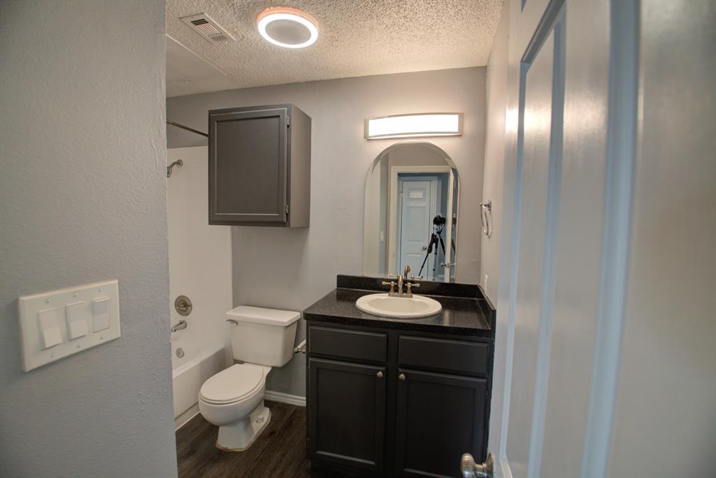 2606 Rio Grande Street, Unit 305 Austin, TX 78705 - Photo 12 of 18 a bathroom with a toilet sink and mirror