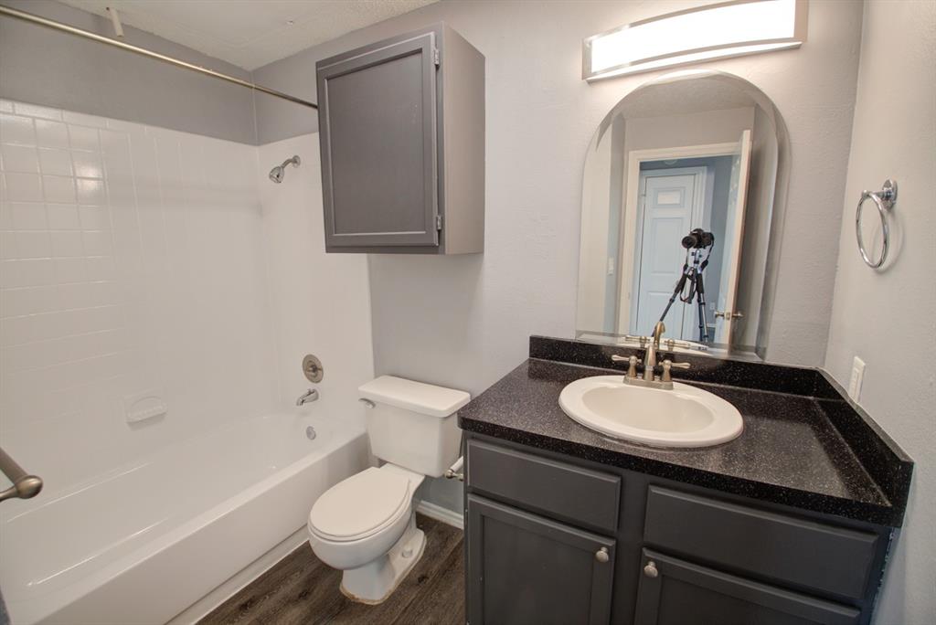 2606 Rio Grande Street, Unit 305 Austin, TX 78705 - Photo 13 of 18 a bathroom with a granite countertop toilet sink and mirror