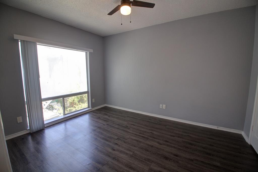 2606 Rio Grande Street, Unit 305 Austin, TX 78705 - Photo 14 of 18 an empty room with wooden floor and windows