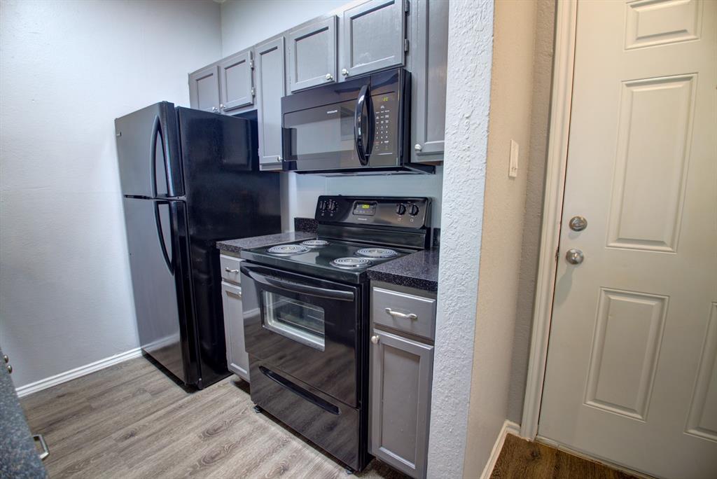 2606 Rio Grande Street, Unit 305 Austin, TX 78705 - Photo 3 of 18 a kitchen with stainless steel appliances granite countertop a refrigerator microwave and sink