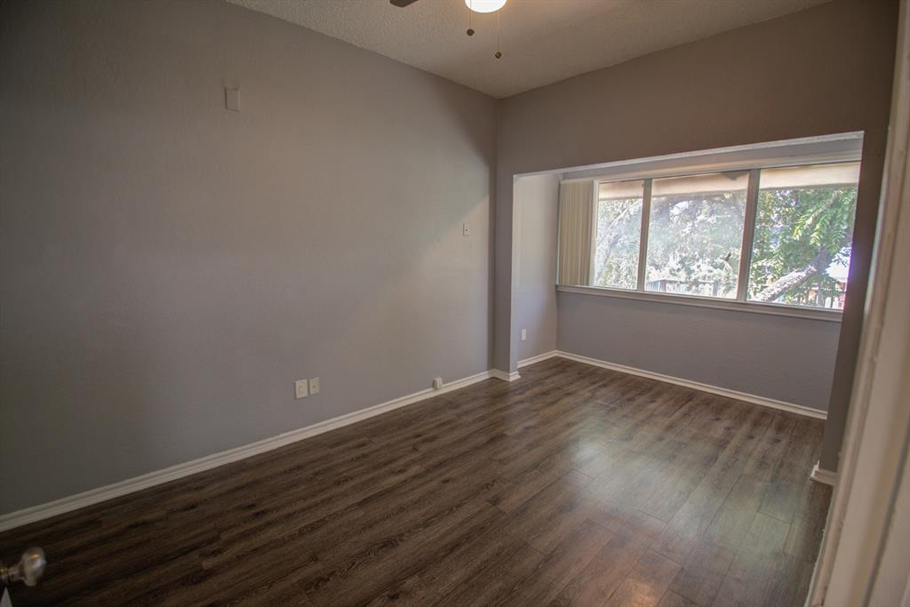 2606 Rio Grande Street, Unit 305 Austin, TX 78705 - Photo 7 of 18 an empty room with wooden floor and windows