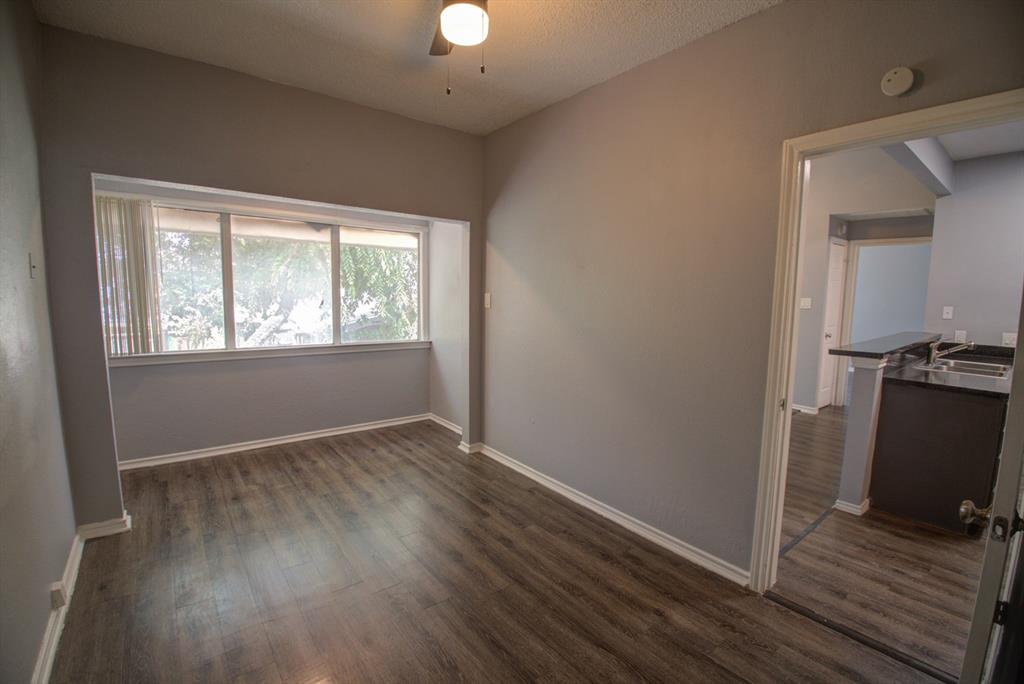 2606 Rio Grande Street, Unit 305 Austin, TX 78705 - Photo 8 of 18 an empty room with wooden floor cabinet and windows