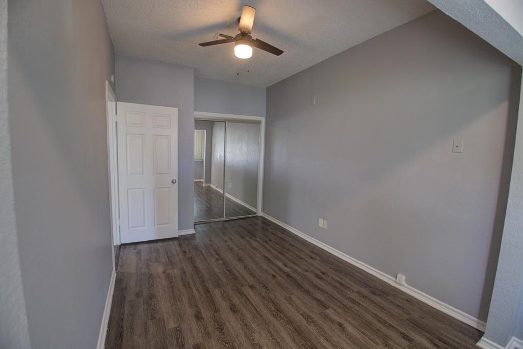 2606 Rio Grande Street, Unit 305 Austin, TX 78705 - Photo 10 of 18 an empty room with wooden floor chandelier fan and closet area
