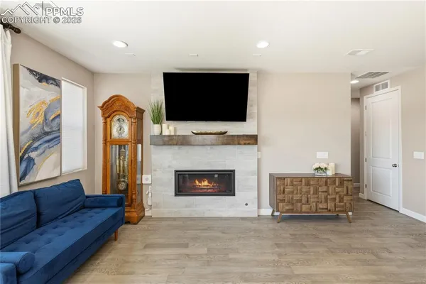 a living room with furniture a flat screen tv and a fireplace