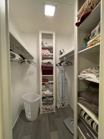 a view of walk in closet with clothes and shoes