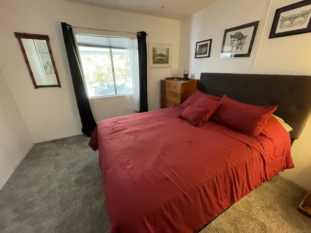 a bed sitting in a bedroom next to a window