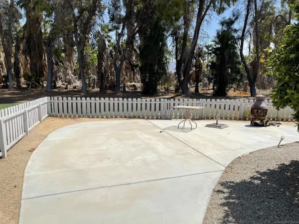 a view of a house with backyard water fountain and sitting area