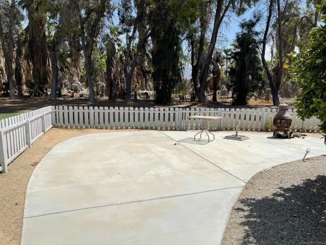 a view of a house with backyard water fountain and sitting area