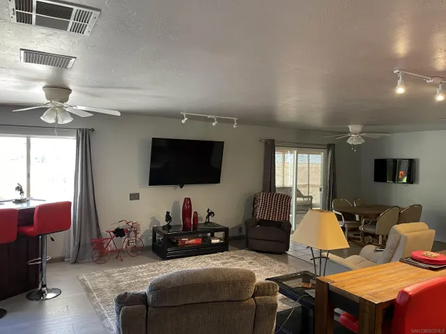 a living room with furniture a flat screen tv and a window