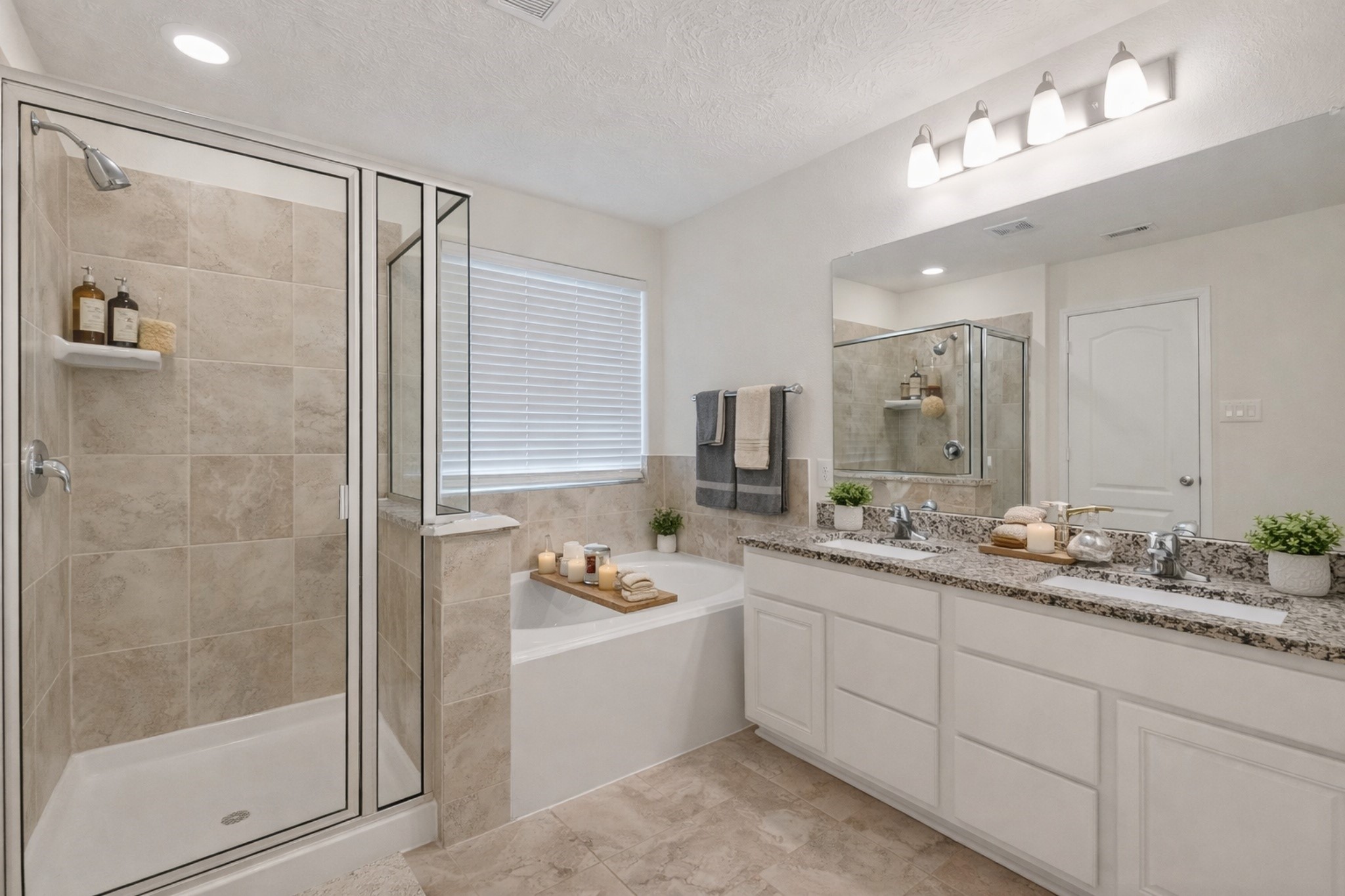 2107 Parnevik Place Conroe, TX 77304 - Photo 25 of 44 The primary ensuite bath features a soaking tub, separate shower, granite countertop, and double wash basins. digitally enhanced