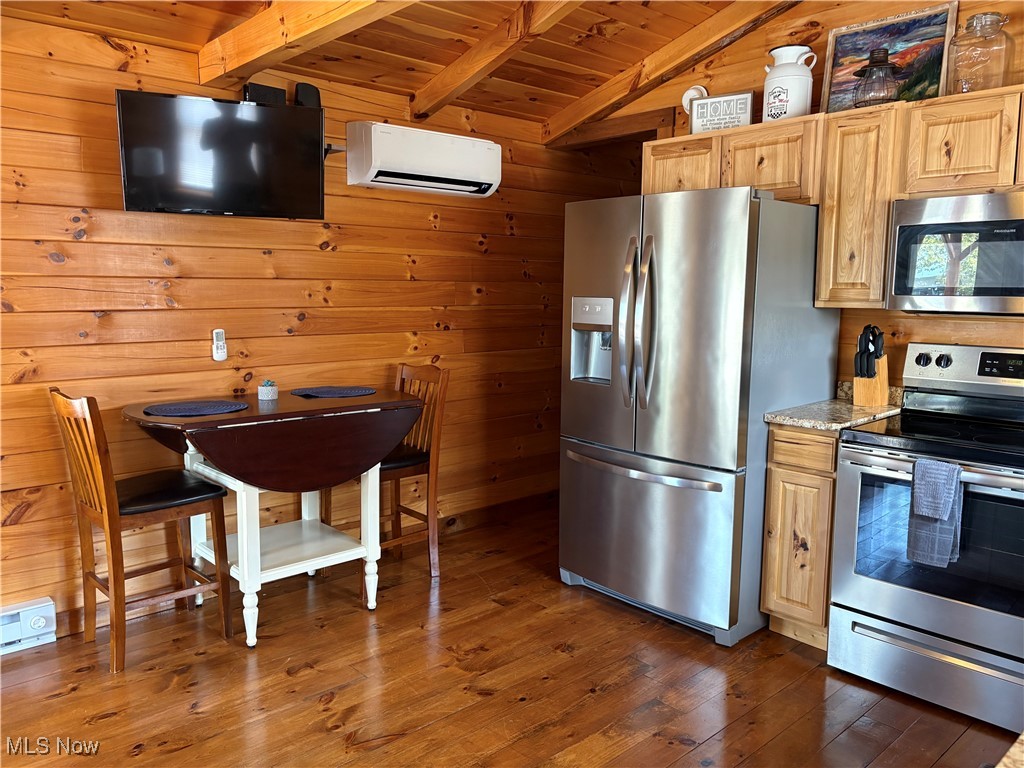 5919 Lake Road West, Unit 7 Ashtabula, OH 44004 - Photo 12 of 29 Kitchen with wood walls, appliances with stainless steel finishes, dark wood-style flooring, a wood ceiling with exposed beams, and a wall mounted air conditioner