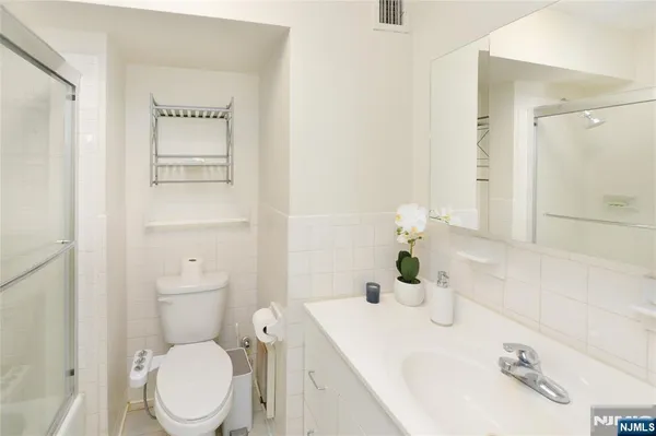 a bathroom with a sink a toilet and mirror