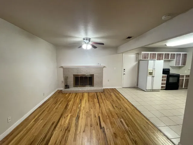 a view of empty room with wooden floor and fireplace