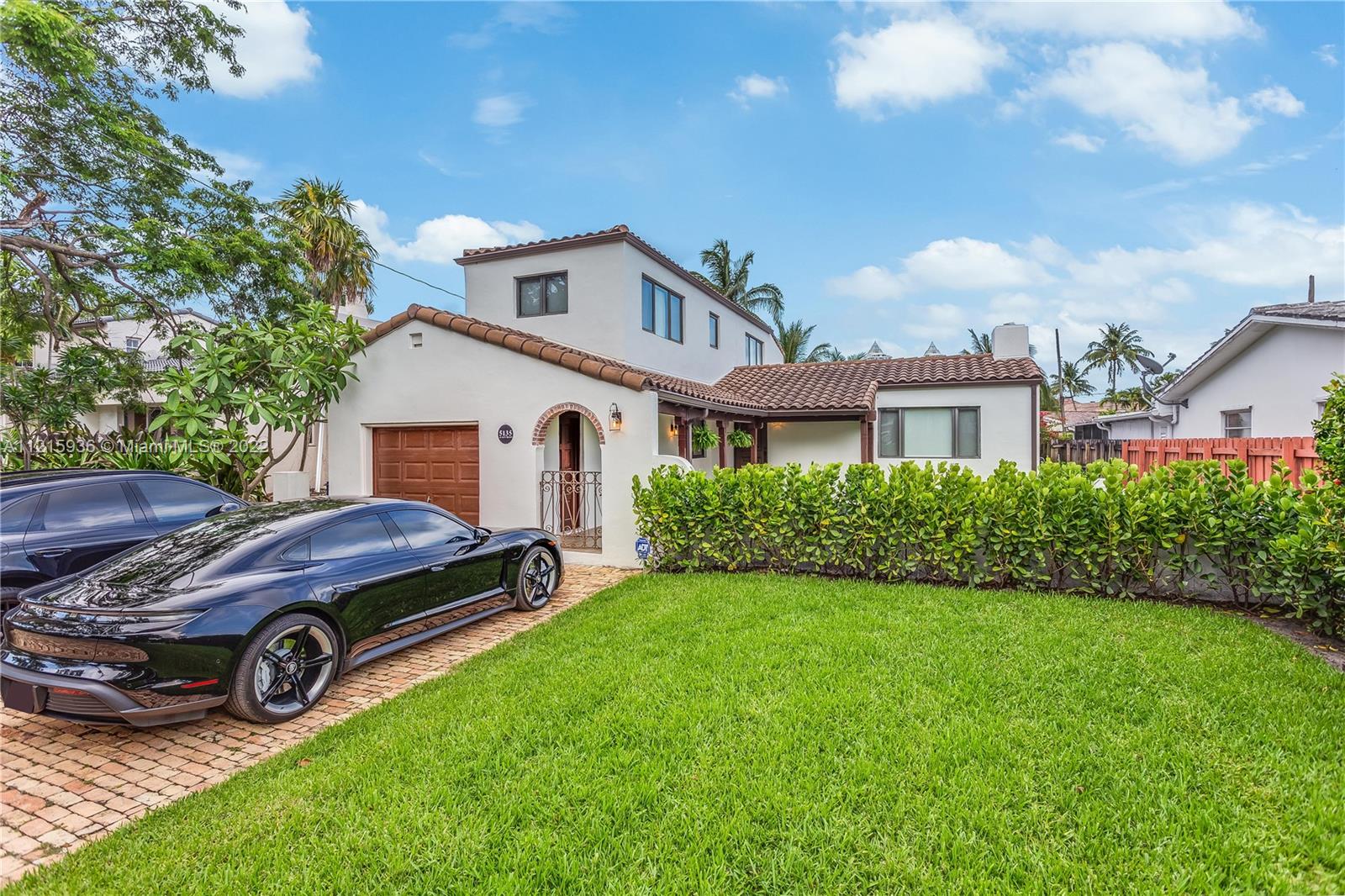 a car parked in front of a house with a big yard