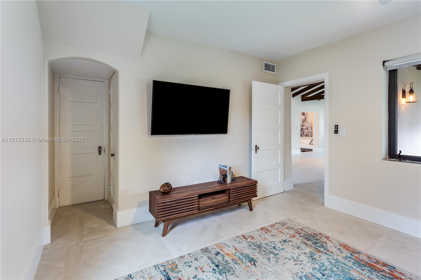 5135 Alton Road Miami Beach, FL 33140 - Photo 12 of 23 a living room with furniture and a flat screen tv