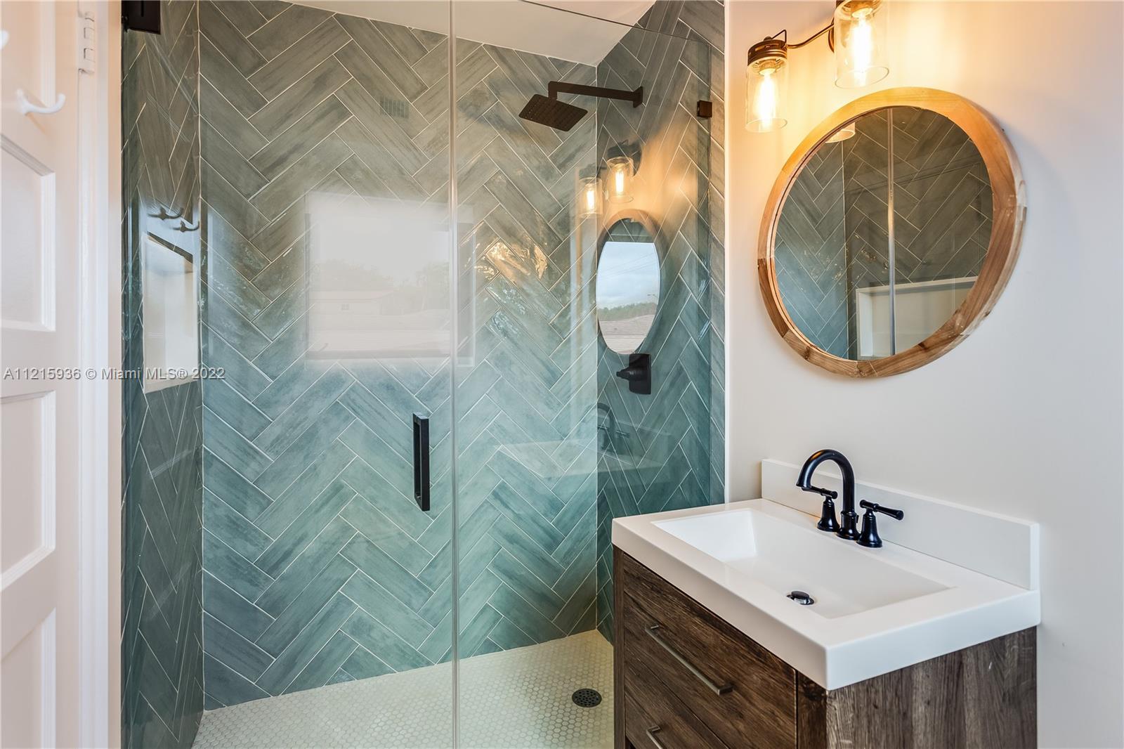 5135 Alton Road Miami Beach, FL 33140 - Photo 14 of 23 a bathroom with a sink and a mirror