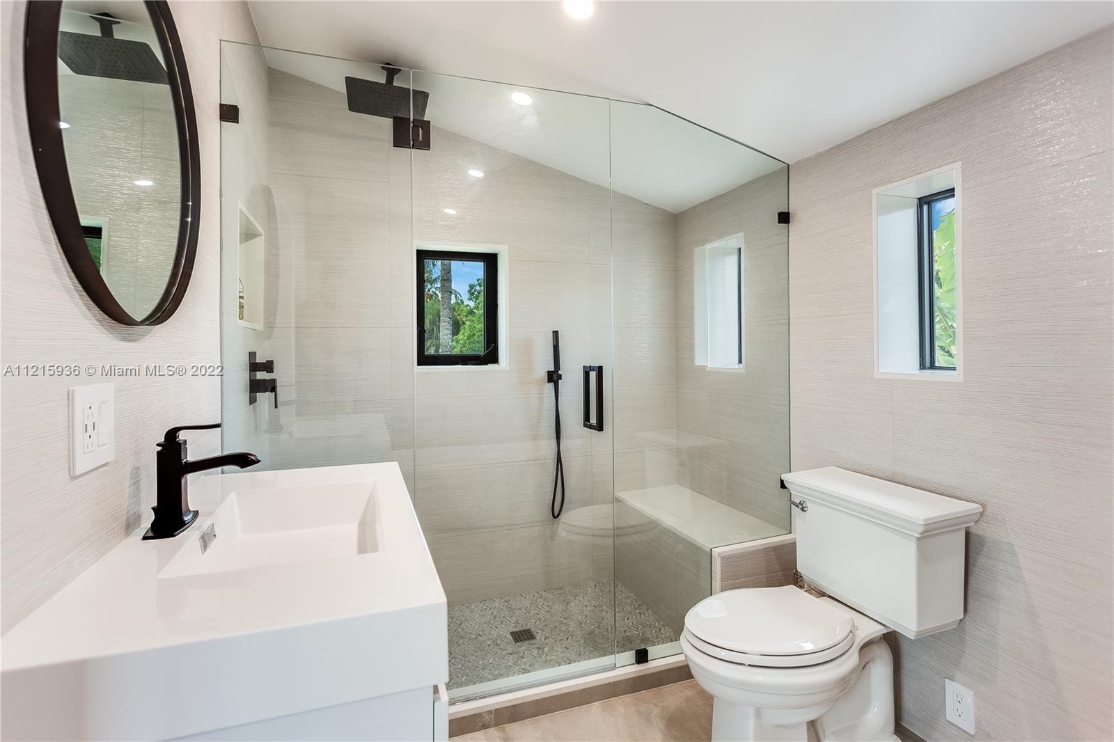 5135 Alton Road Miami Beach, FL 33140 - Photo 20 of 23 a bathroom with a toilet a sink and a mirror