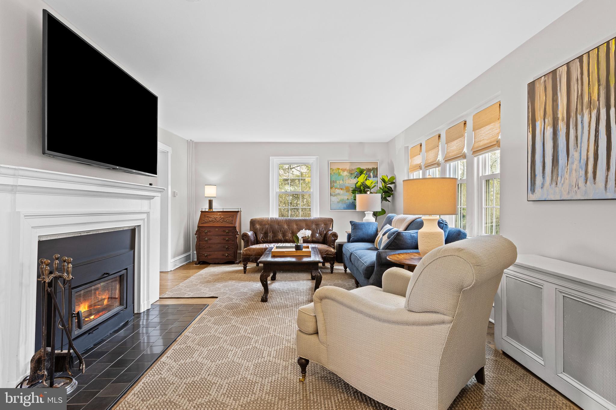 321 Conestoga Road Wayne, PA 19087 - Photo 5 of 28 a living room with furniture a fireplace and a flat screen tv
