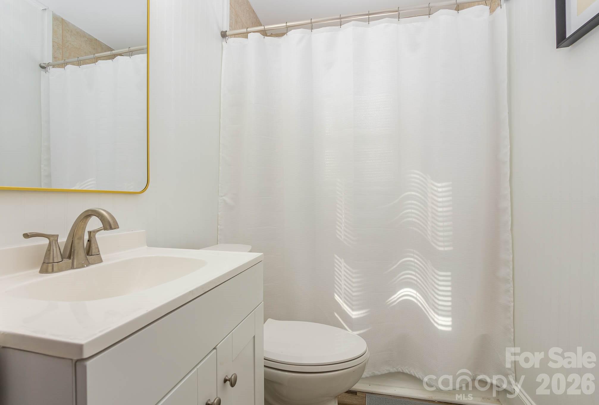 3141 Mathis Drive Charlotte, NC 28208 - Photo 11 of 12 a bathroom with a sink a toilet and shower curtain